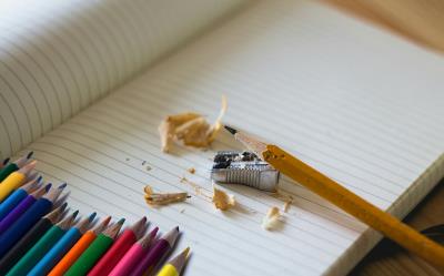 Materiale scolastico: pastelli, matita, temperamatite, quaderno.